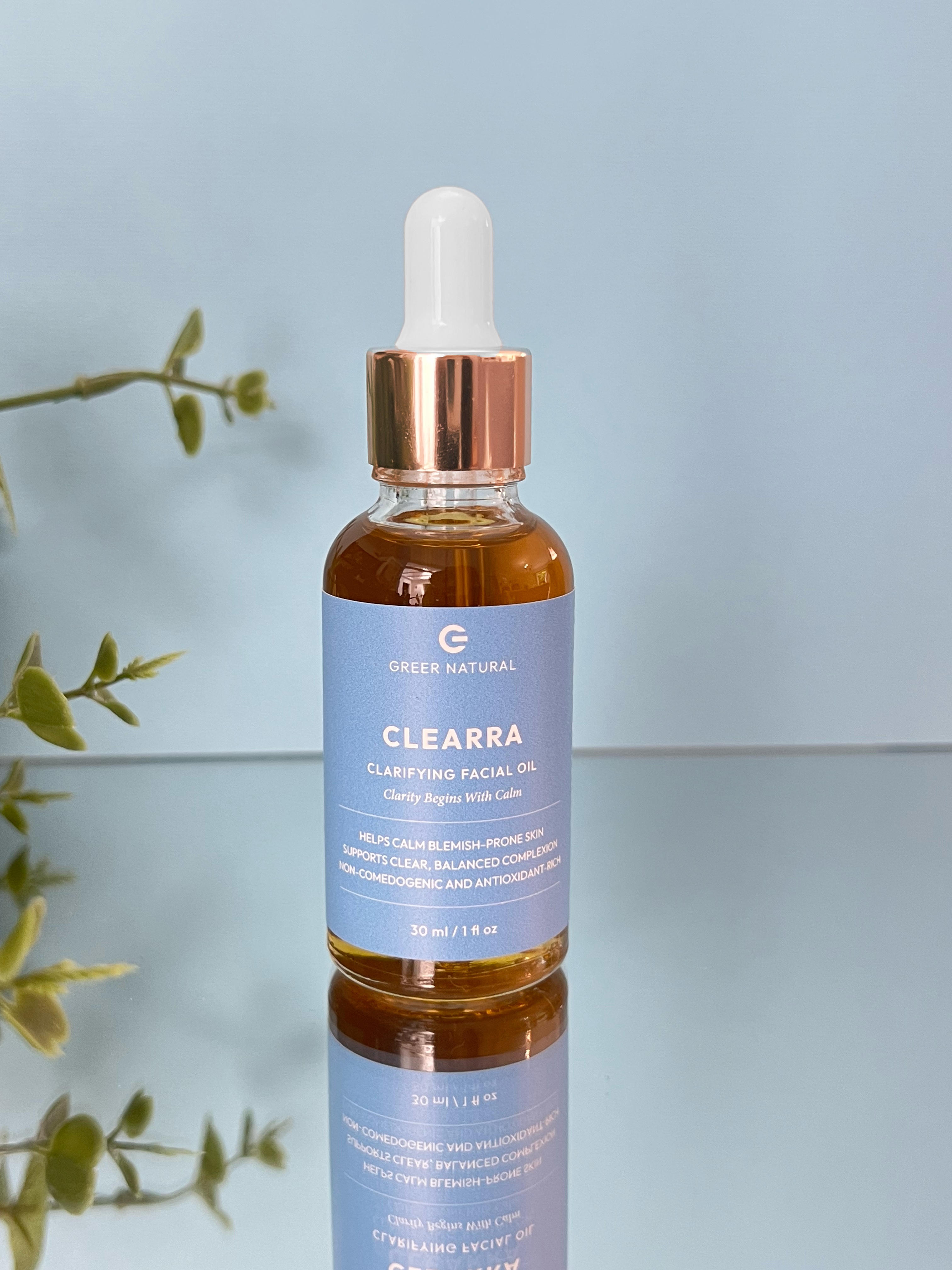 Bottle of Clearra facial oil with dropper on a light blue background