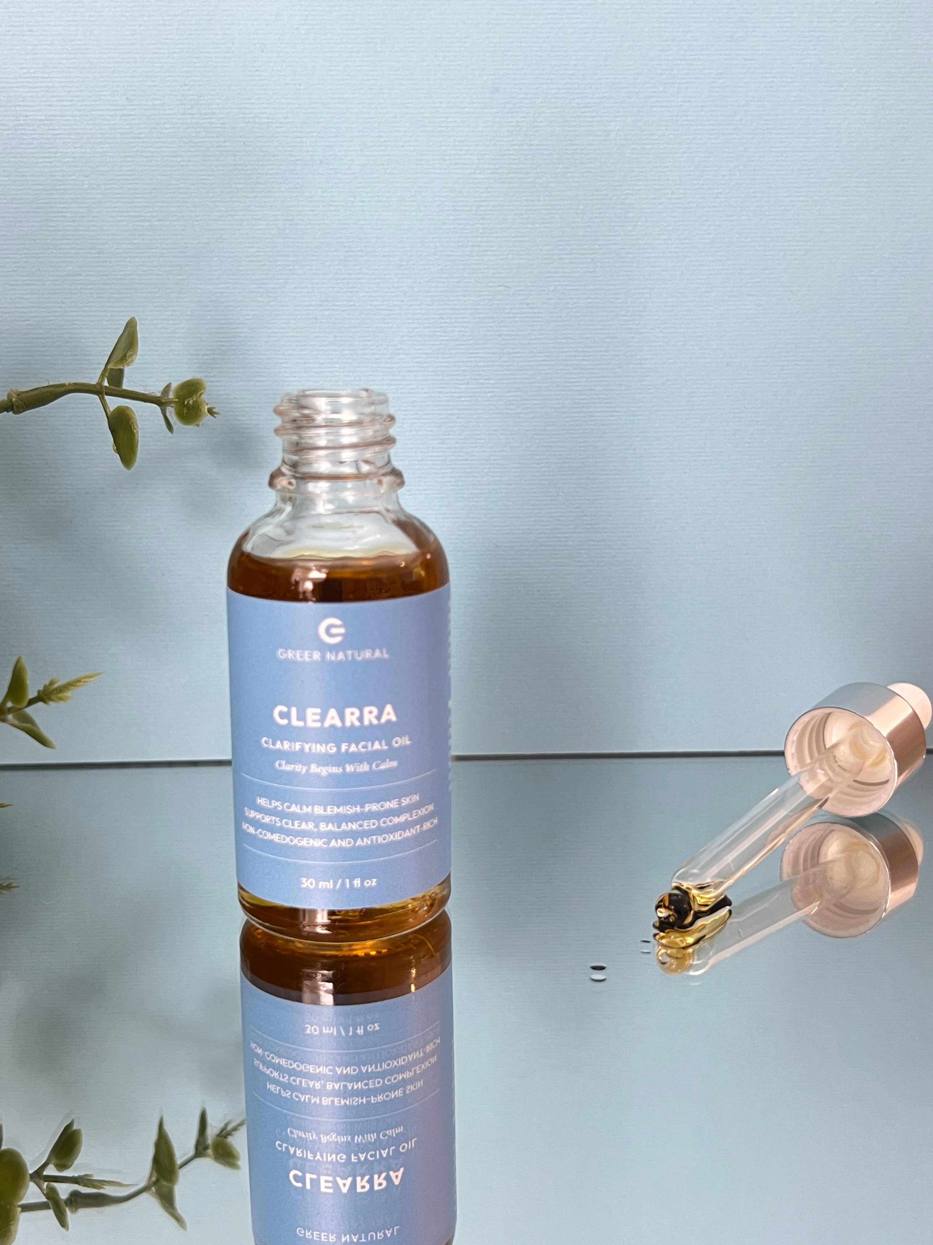 Clearra clarifying facial oil bottle with dropper on a reflective surface