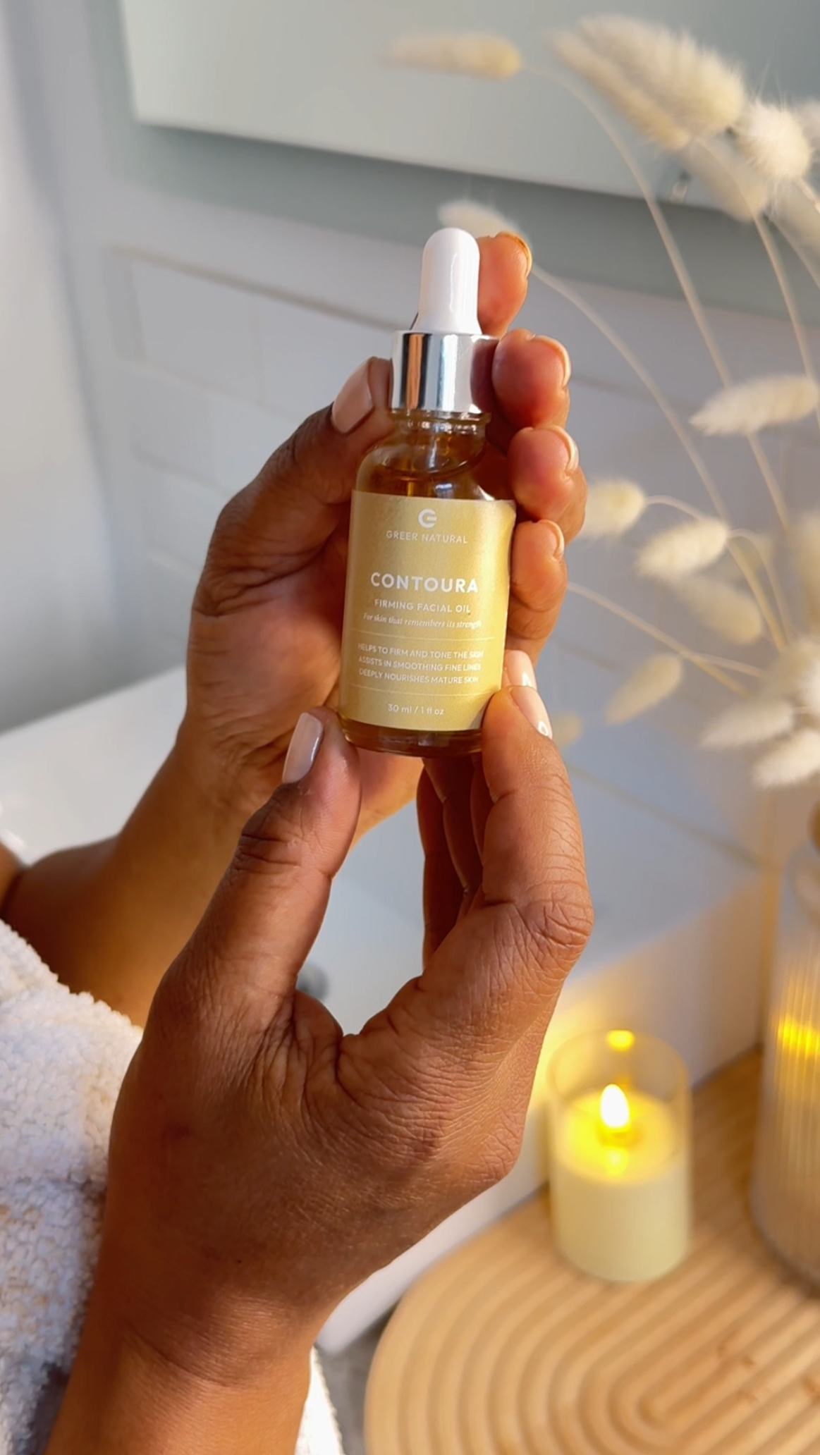 Hand holding a skincare serum bottle with a blurred background