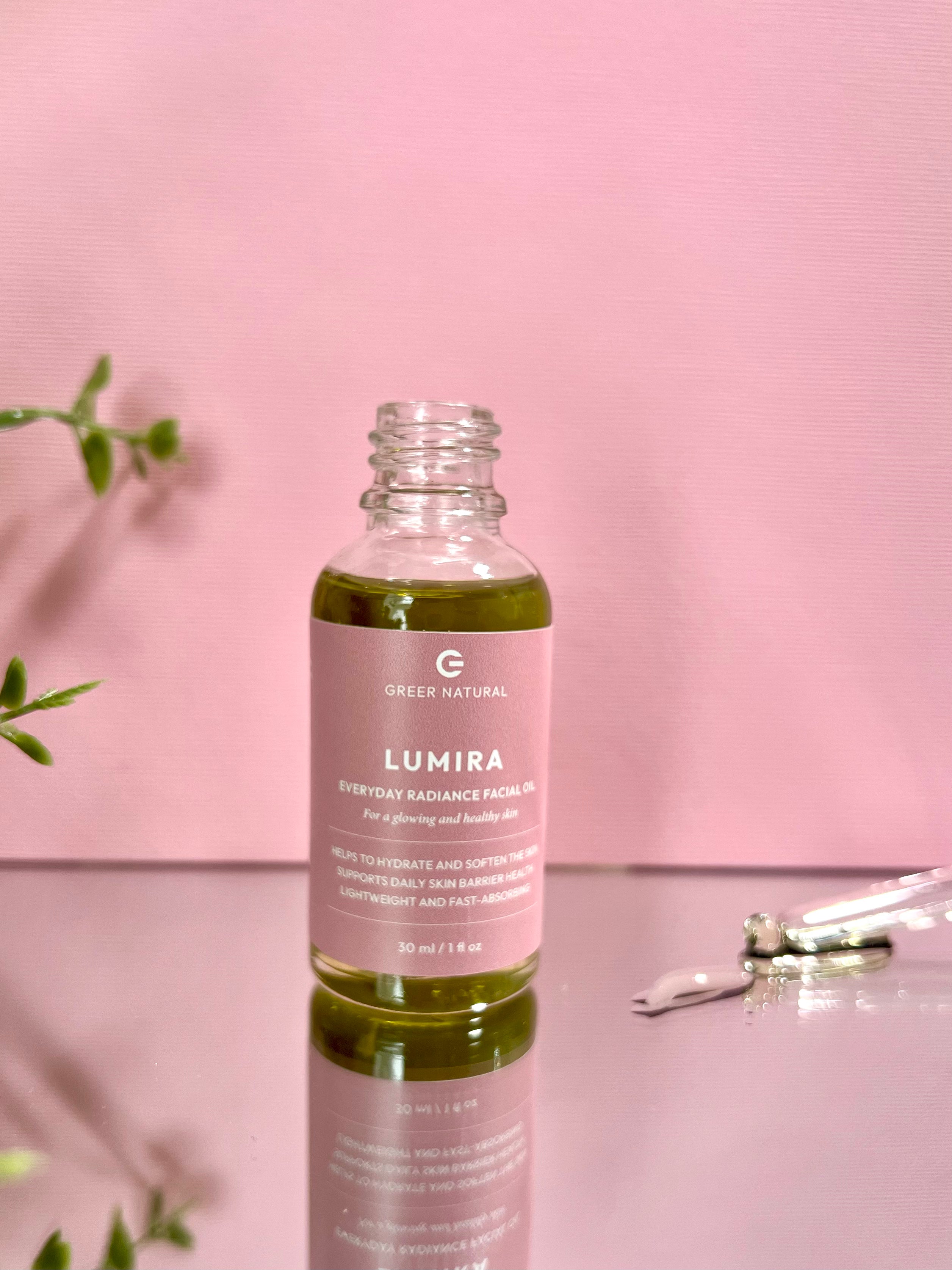Lumira facial oil bottle with pink label on a pink background