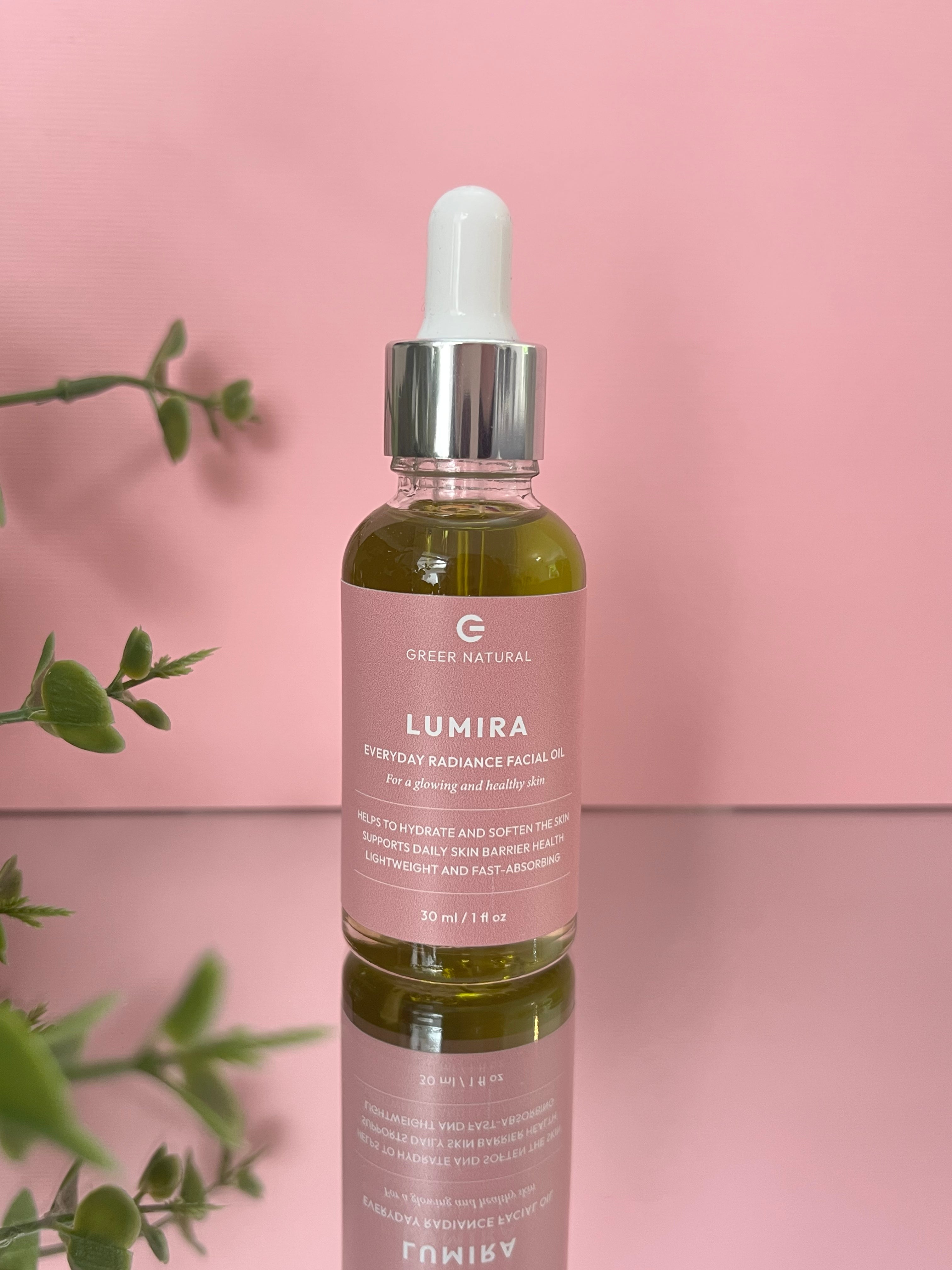 Skincare dropper bottle facial oil with pink label on a pink background