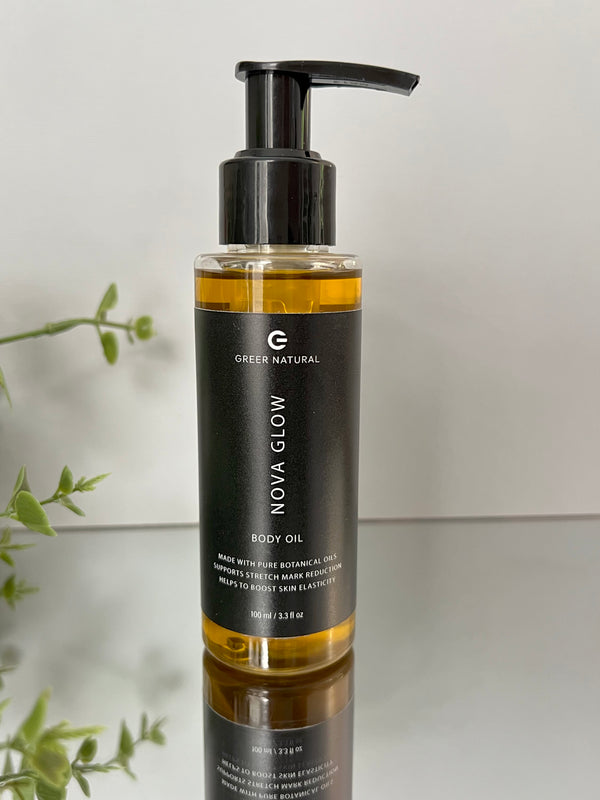 Body oil bottle with pump on a reflective surface and light background