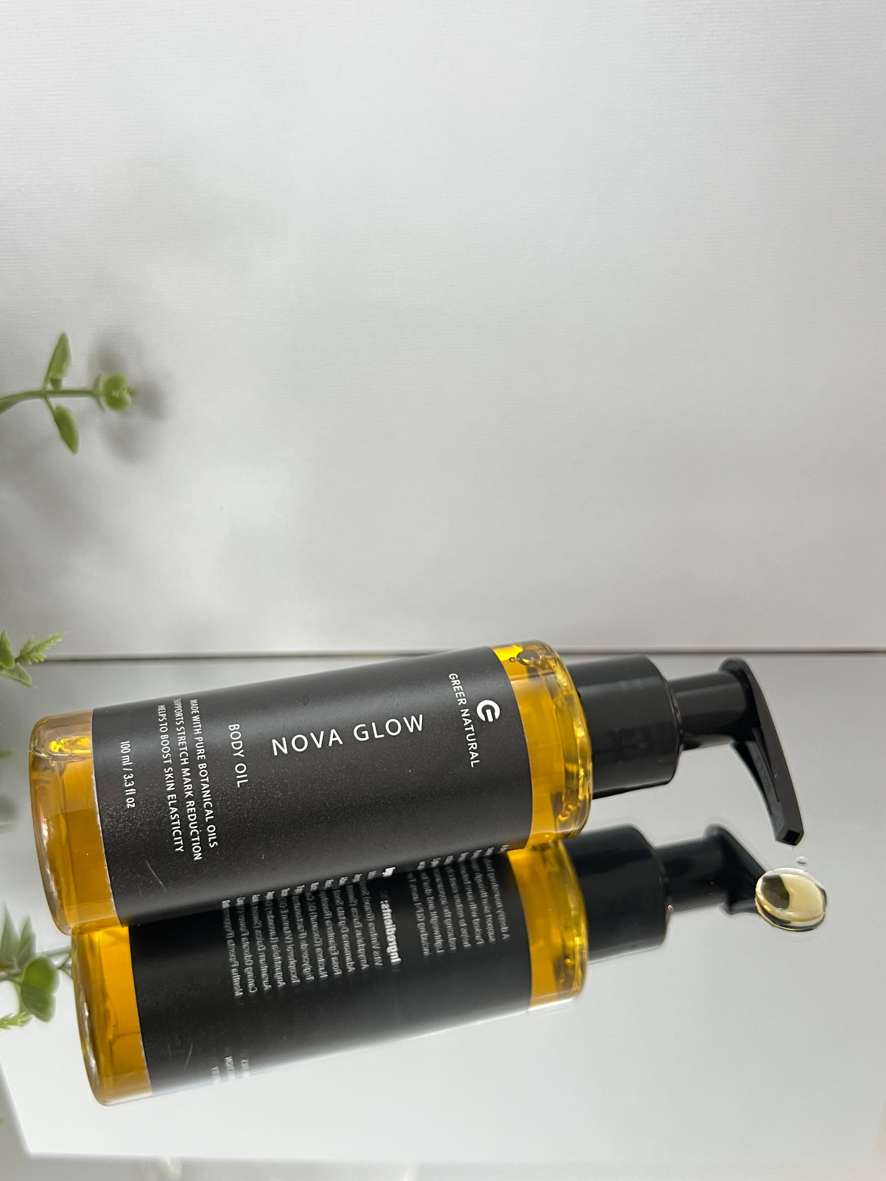 Bottle of Nova Glow body oil on a light gray background